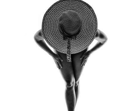 Woman with hat in the backlight, studio shot