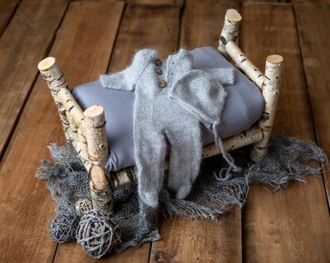 Birchwood cot with grey knitted romper with cap on it, for newborn photography