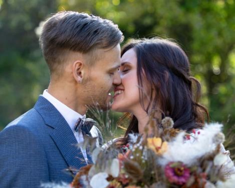 Portrait of a bridal couple kissing outdoors