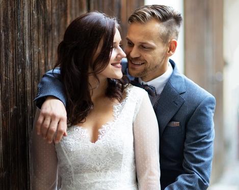 Wedding couple in front of a rustic wooden wall