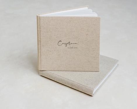 Quadratisches Fotobuch in sand farbigem Leineneinband und aufgedrucktem Monogramm