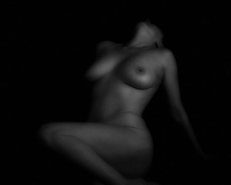 Image of a half-lying woman in accentuated light, b/w picture