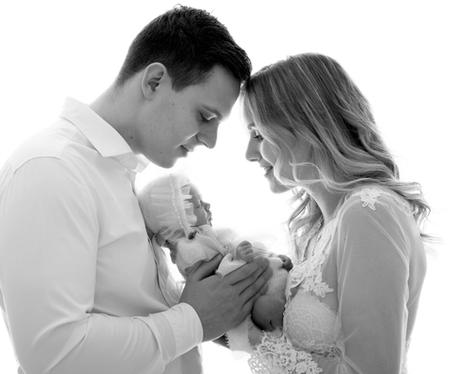 Parents with their newborn baby in pofil view against white background