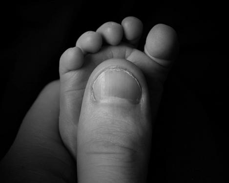 Detail von Babyfuß in Vaters Hand