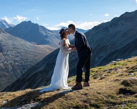 Bride and groom kissing in the mountains