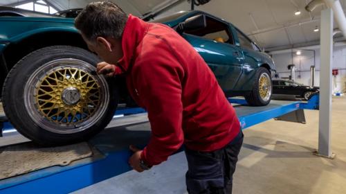 Man utför kontroll på bil.