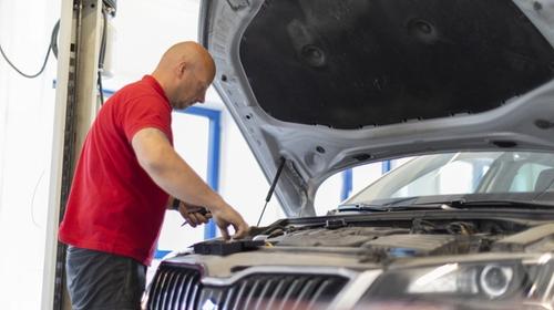 Takstmann som utfører eierskiftekontroll på bruktbil.