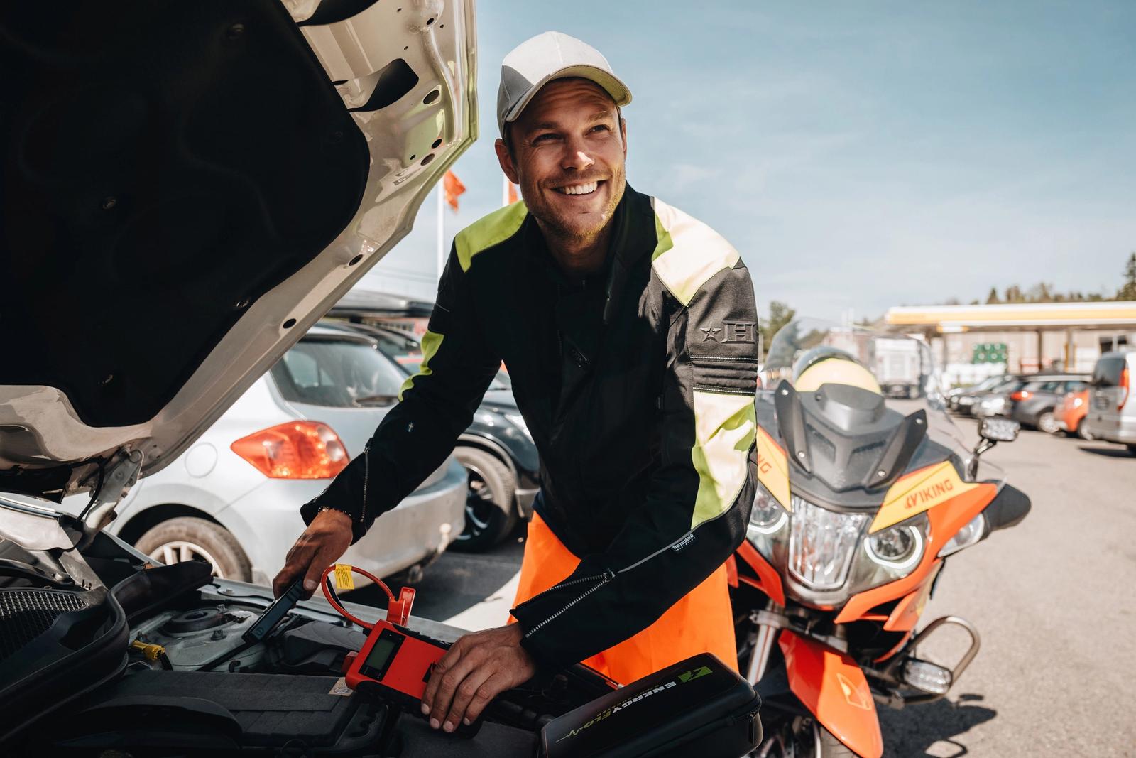 Vikingin tiepalvelun työntekijä mittaa auton akun jännitettä parkkipaikalla.