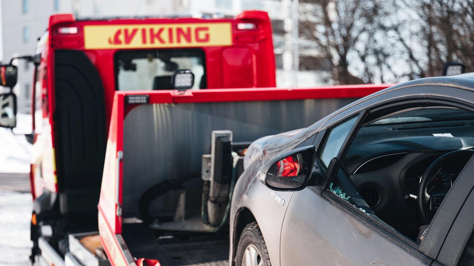 Viking hinausauto kuljettaa vaurioitunutta harmaata autoa.