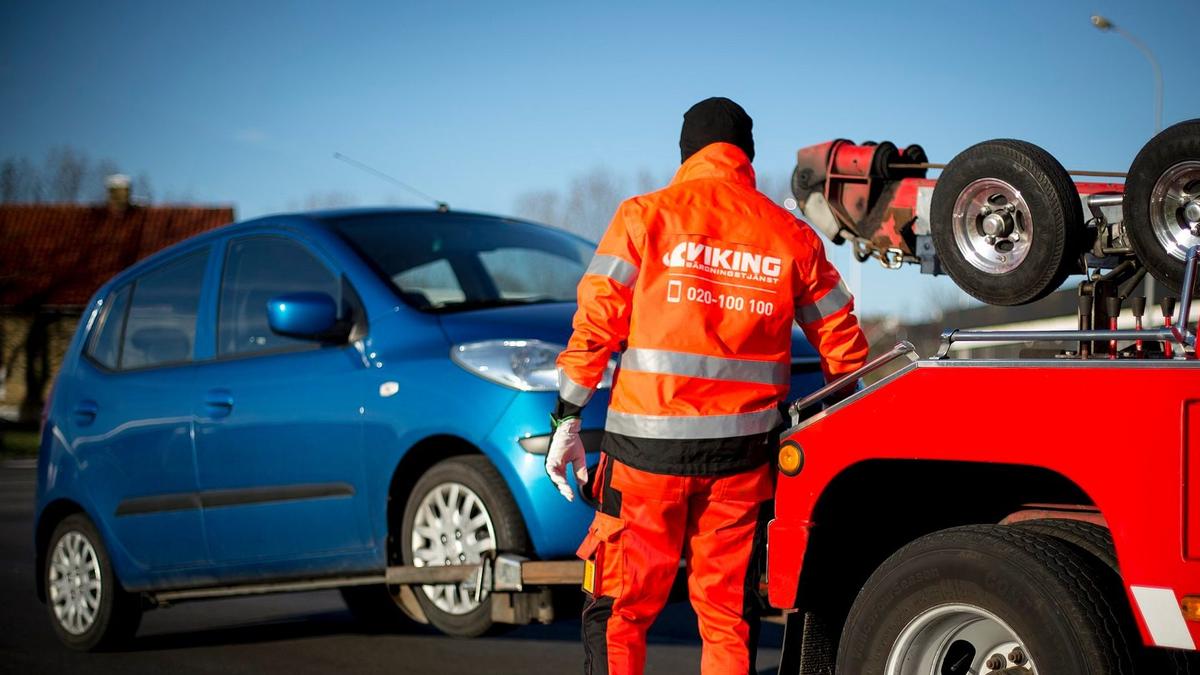 Mand fra Viking bugseringstjeneste bugserer en blå bil.