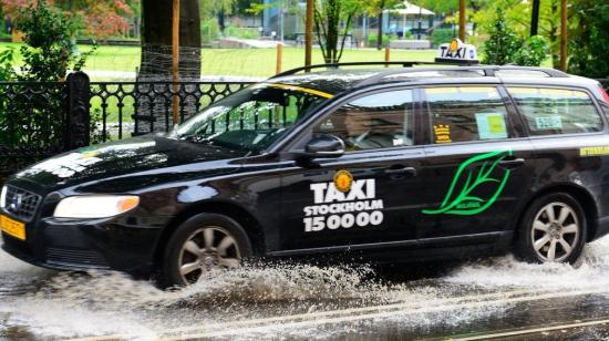 Taxibil kör på vått underlag.