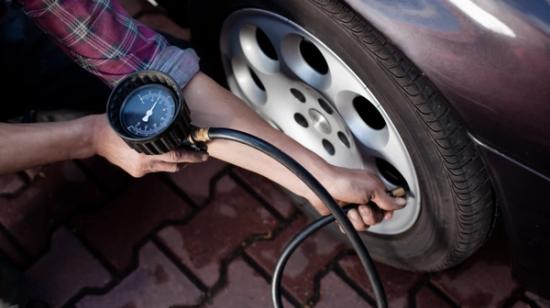 Person kontrollerer dæktrykket.