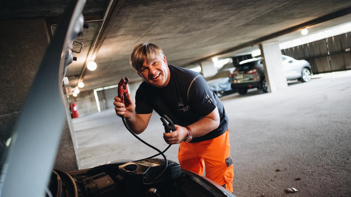 Person som starter bil med flatt batteri.