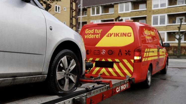 En Viking bergingsbil merket tauer en bil med punktert dekk i et boligområde.