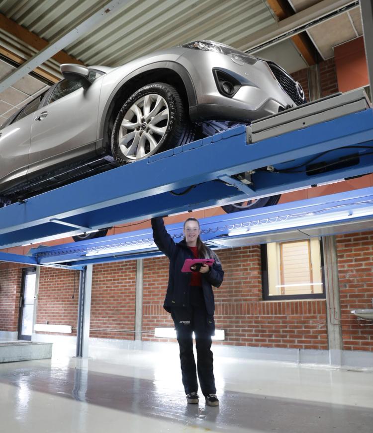 Dame utfører kontroll av bil.