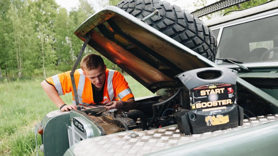 Person som bruker starbooster til å starte bil med flatt batteri.