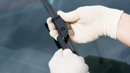 Person, der skifter vinduesviskere med lige arm.