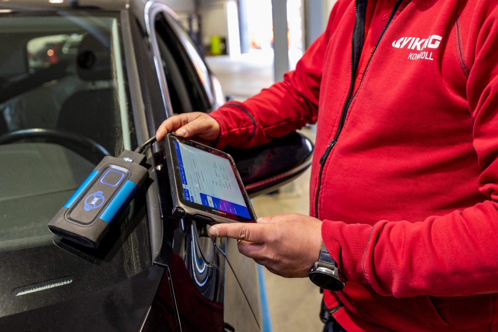 Man utför kontroll på bil.