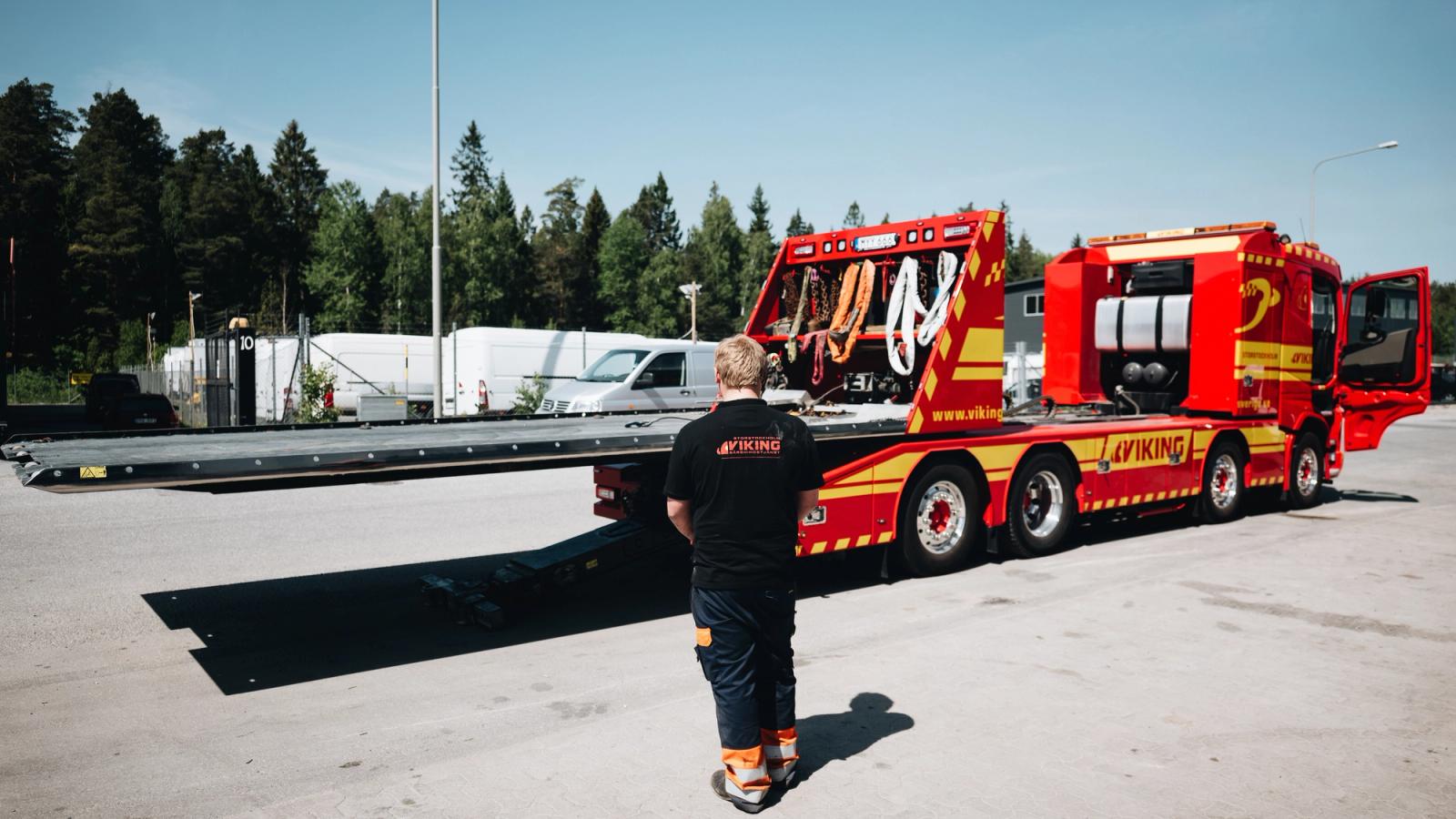 Hinausauton kuljettaja laskee hinausauton lavaa.