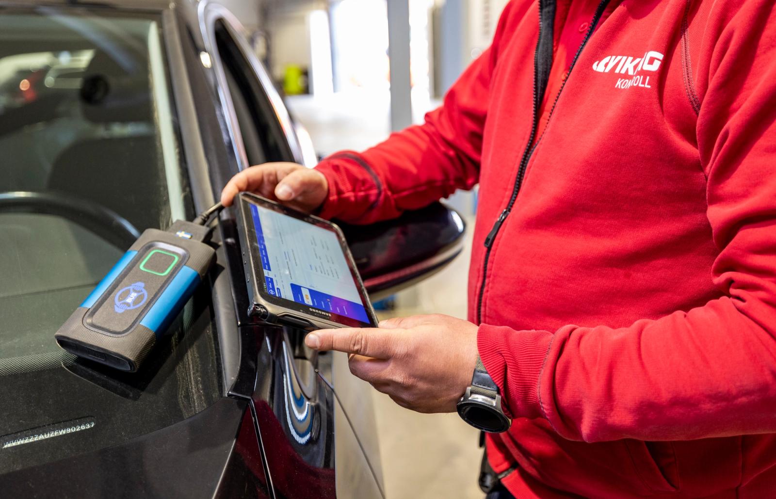 Mann utfører kontroll på bil.