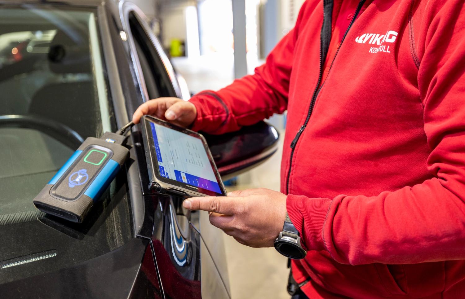 Man utför kontroll på bil.