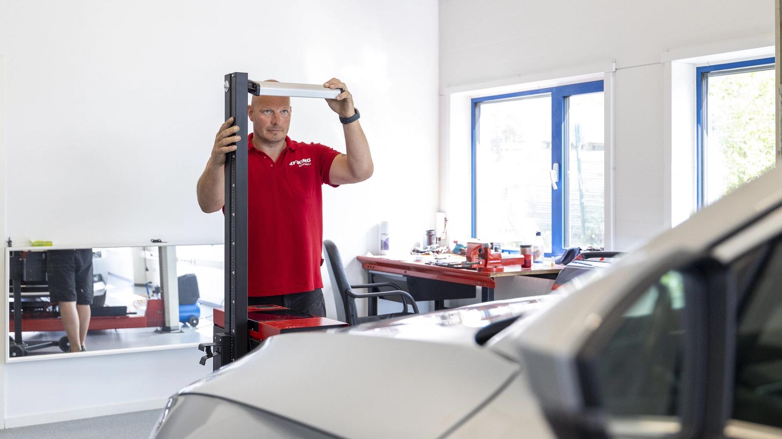 Takstmann som utfører EU-etterkontroll av en personbil.