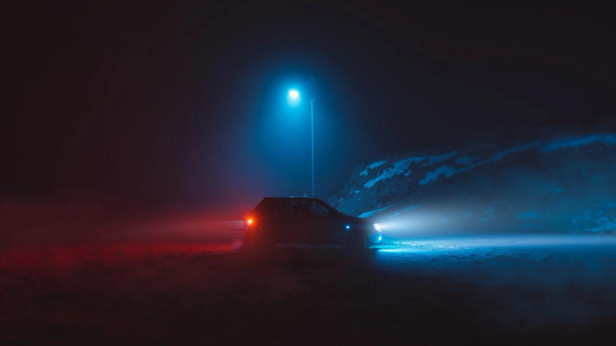 Bil i mørke på en grusvej.