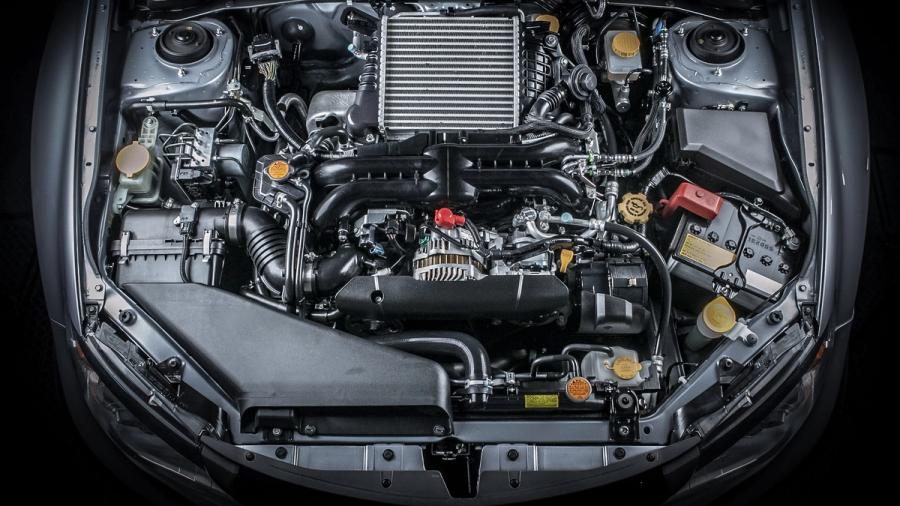 Visning av motorrom på en bil, som viser ulike komponenter som slanger, belter, radiatoren, batteriet og andre mekaniske deler.