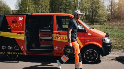 Bilberger bruker startbooster til å starte flatt bilbatteri.