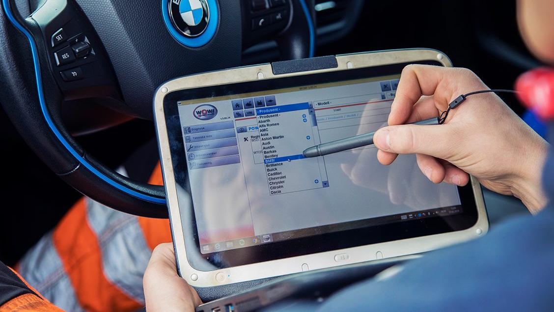 Mekaniker utför arbete på bil via dator.