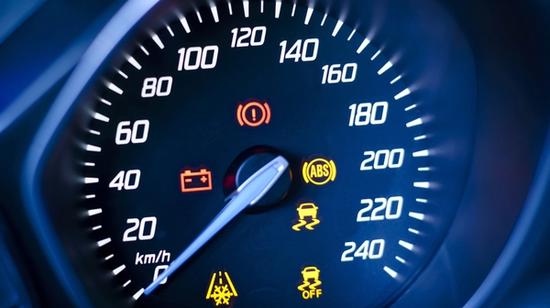 Auton nopeusmittari, jossa palaa useita varoitusvaloja.