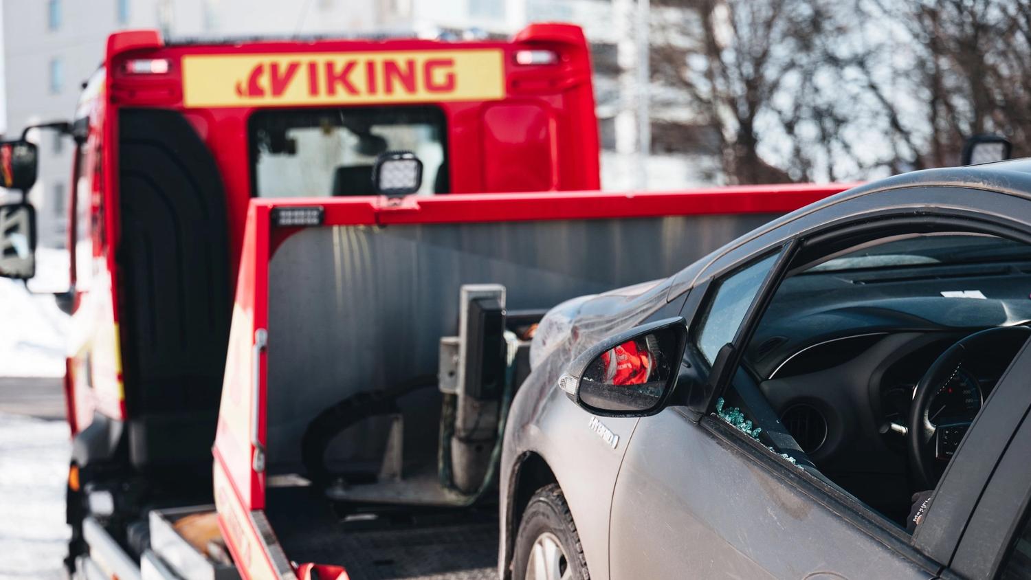 Bil med krossat fönster på planet på en Viking-bärgningsbil på vägassistansuppdrag.