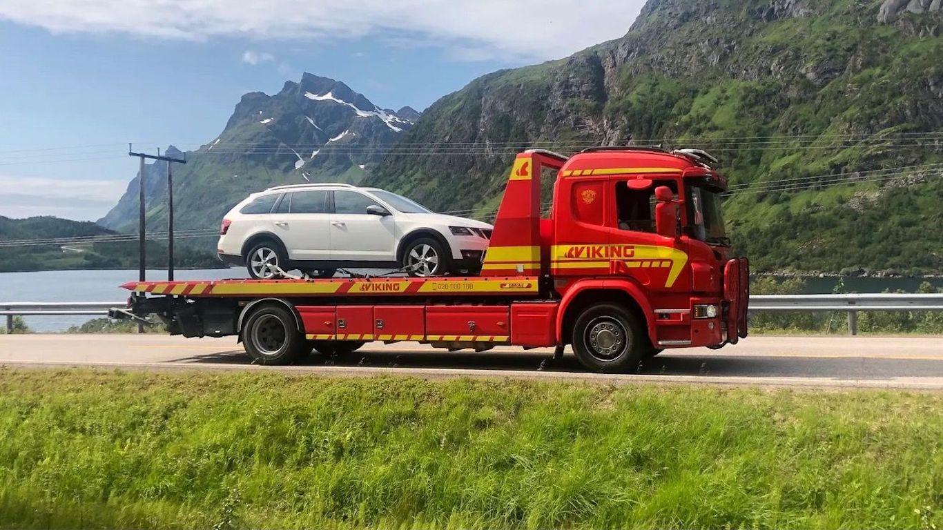 Bil med knust rute oppå planet til en Viking bergingsbil på veihjelpsoppdrag.