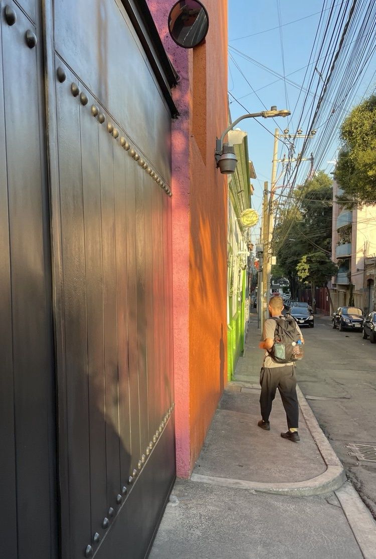 Ambiguous human figure walking down a colorful street