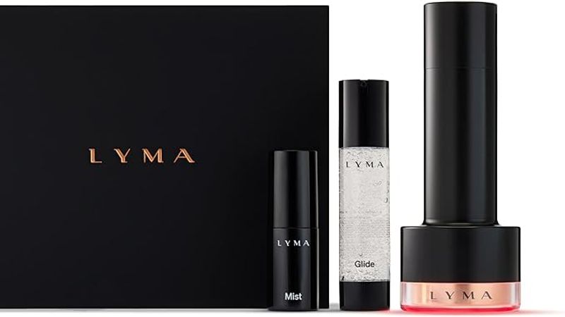 At-home skin devices for resurfacing and rejuvenation — LYMA Laser PRO, NuFACE Trinity+, and CurrentBody LED Mask on a marble surface.