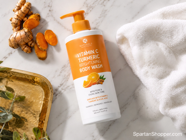 Kojic acid turmeric body wash bottle with turmeric root flat lay on white marble