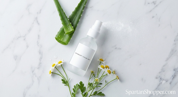 Hypochlorous acid facial spray with aloe and chamomile flat lay on white marble