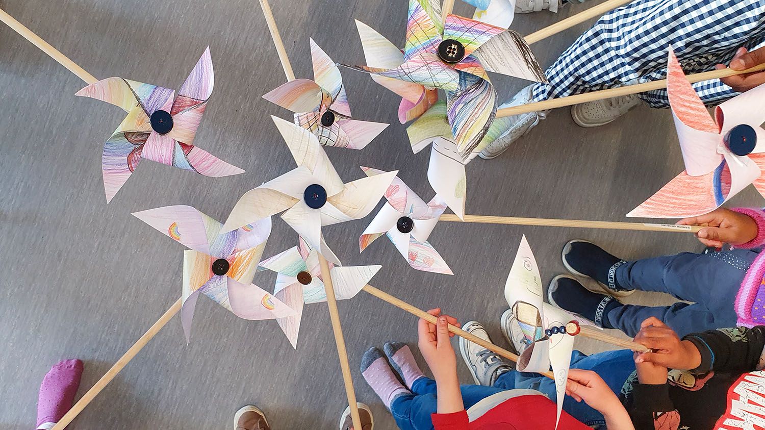 barn holder papirvindmøller i en sirkel