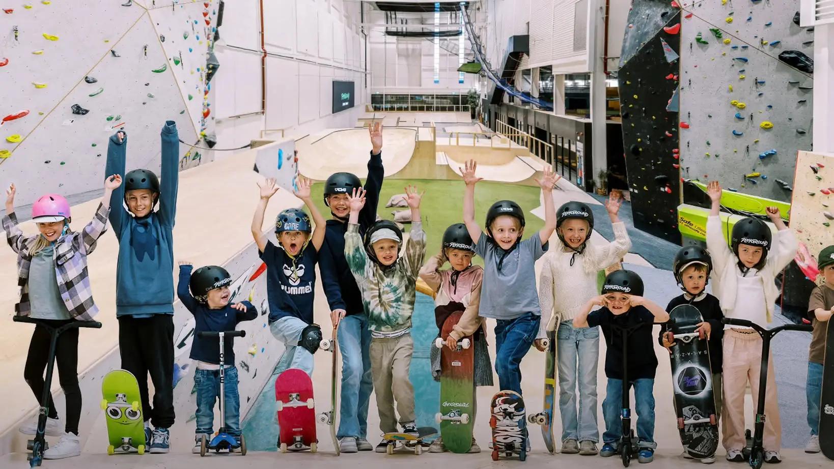 mange barn med skateboard og armene i været i aktivitetshall