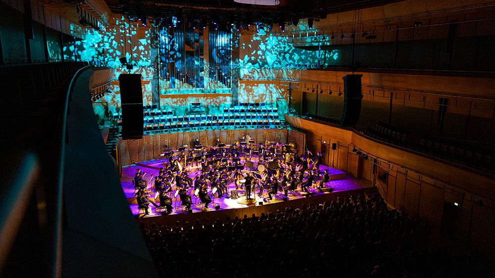 orkester på scenen i mørk sal