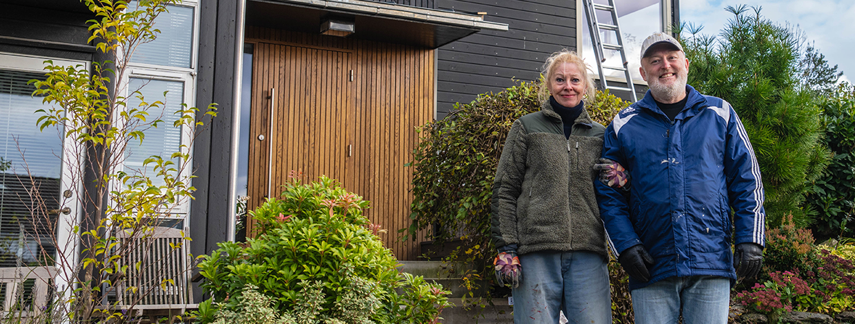 Voksent par foran ytterdør i arbeidsklær