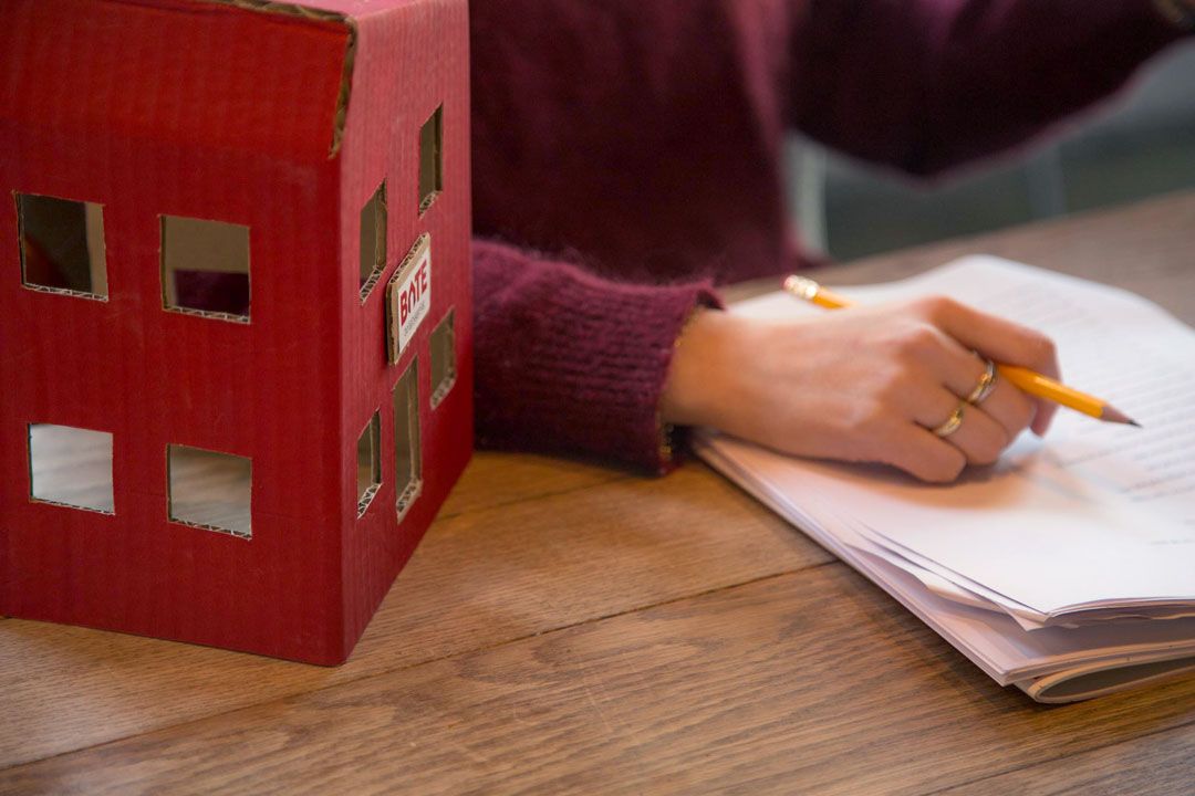 Hånd holder blyant over skriveblokk