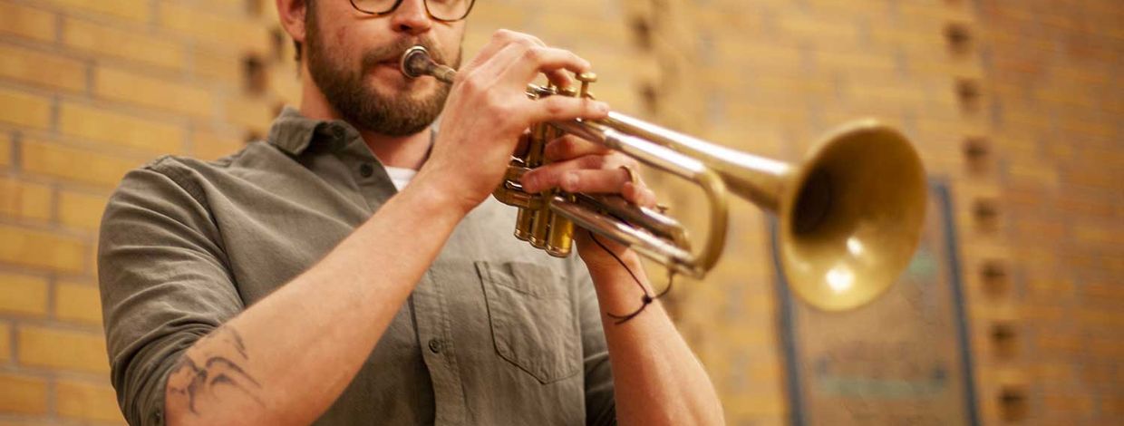 Mann spiller trompet