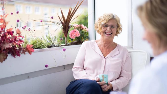 Dame drikker kaffe på balkongen sin