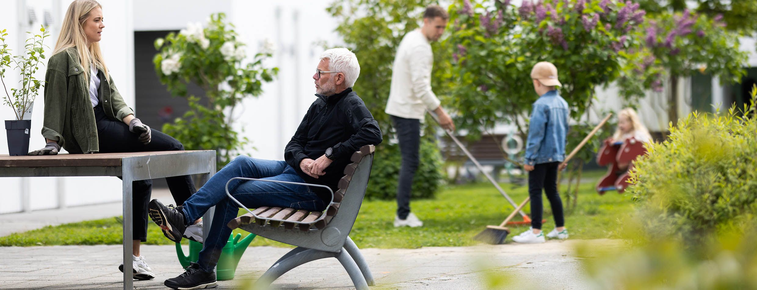 Mennesker sitter i uteområdet til borettslaget