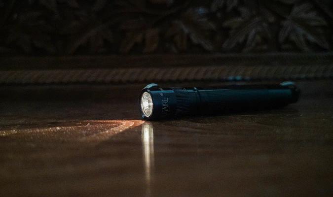 Lommelykt lyser i et mørkt rom