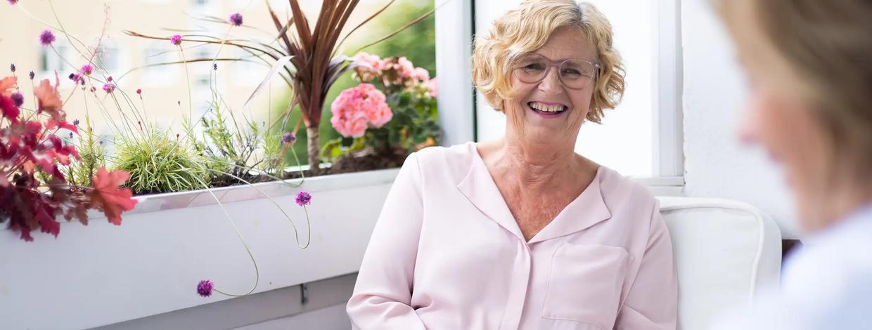 Eldre kvinne i samtale på balkongen