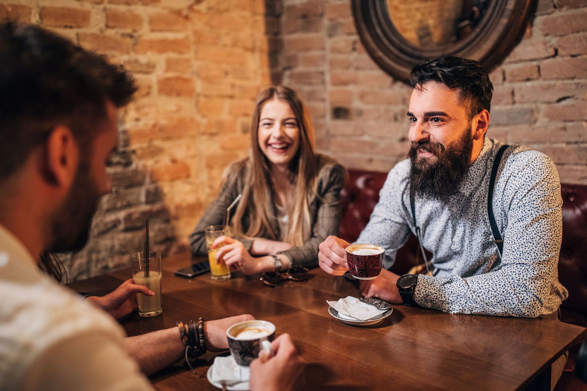 Venner som drikker kaffe sammen rundt et bord