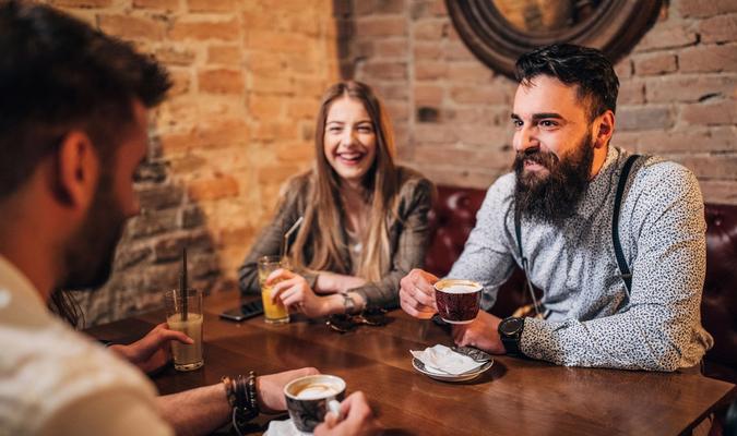 Venner som drikker kaffe sammen rundt et bord