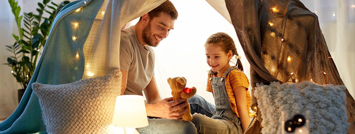 Far og datter i telt med lys